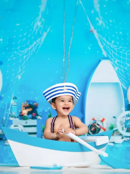 Ahoy, little sailor! This joyful nautical-themed studio shoot shows how we bring imagination to life with creative backdrops and fun props, perfect for a first birthday adventure.