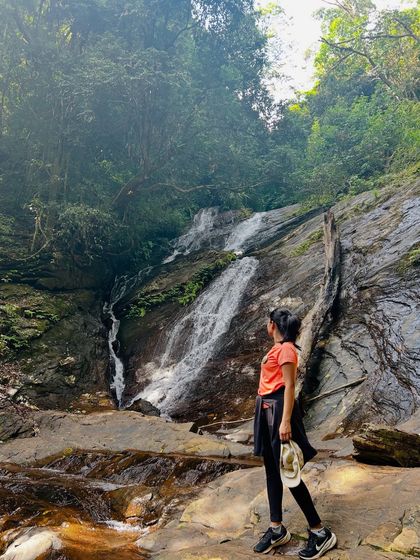 A trekker enjoying the view of a waterfall on the Kodachadri trail.