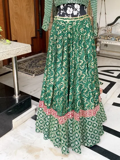 The lower half of the lehenga skirt, showing the intricate patterns and the contrasting red border.