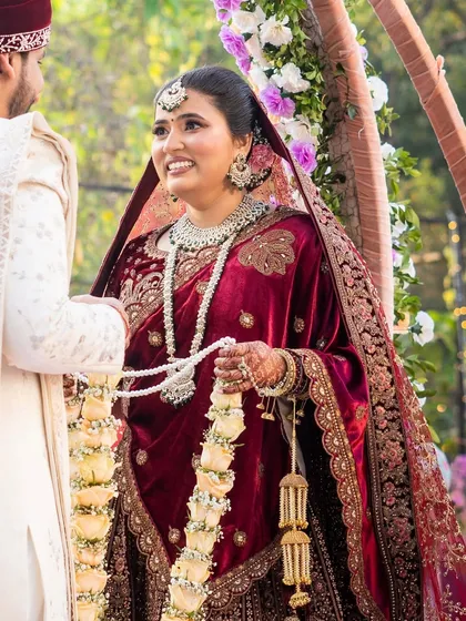 A happy moment between the bride and groom during the varmala ceremony. Her smile shows the joy of the occasion.