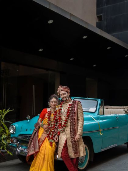 A stylish portrait of the Maharashtrian couple posing with a vintage convertible, adding a cool, cinematic flair to their wedding album.
