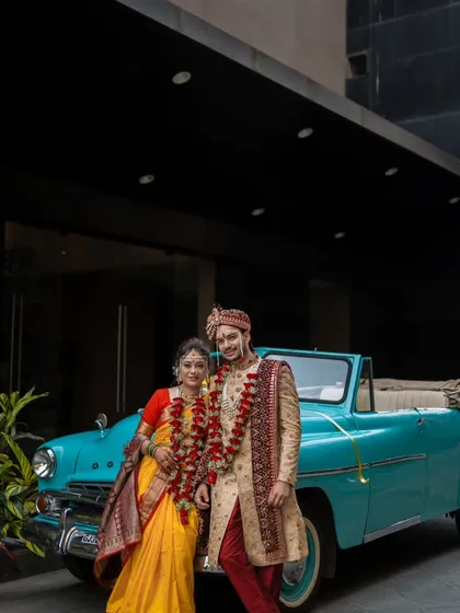 A stylish portrait of the Maharashtrian couple posing with a vintage convertible, adding a cool, cinematic flair to their wedding album.