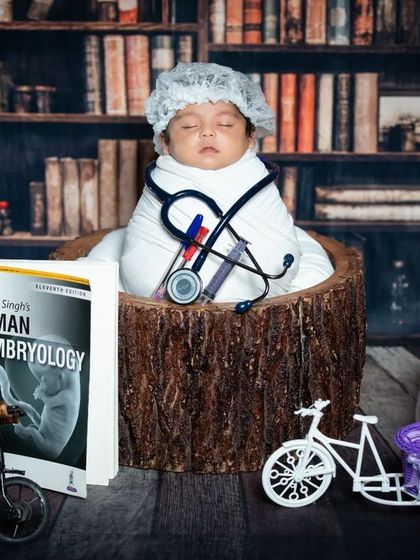 This newborn doctor is deep in study, surrounded by medical textbooks. A great concept for parents in the medical field.