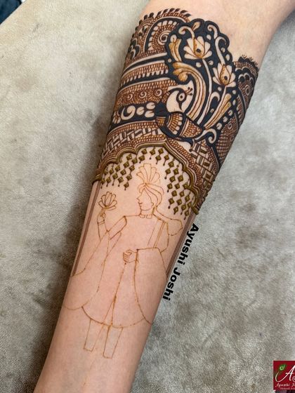 A work-in-progress shot showing the initial outline and partial filling of a groom portrait. This demonstrates the foundational steps to creating detailed figurative mehendi, a technique we cover in depth.