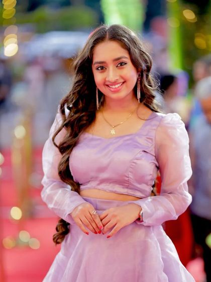 A bright and happy shot of actress Ankitha Jayarama in a lovely lavender outfit, capturing her cheerful energy.
