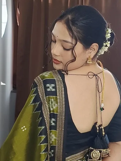 A complete look goes beyond the front pleats. The fall of the pallu at the back, the fit of the blouse, and the hairstyle all come together. This close-up highlights a neat back profile, ensuring you look polished from every perspective.