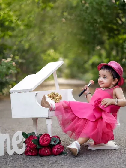 Who says a one year old can't be a little diva? We love getting creative with our outdoor shoots, like this adorable mini piano setup. It’s all about capturing their budding personality in a playful way.