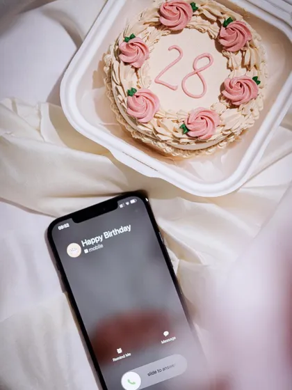 A beautifully styled shot of a bento cake for a 28th birthday, complete with a 'Happy Birthday' call on the phone. It’s all about creating that perfect celebration vibe.