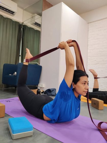 A student works on her Dhanurasana (Bow Pose) with the help of a strap during our workshop. This tool allows for a deeper shoulder opening and quadriceps stretch.