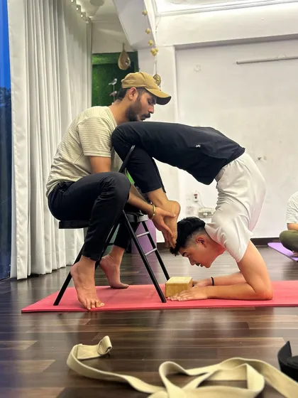 Another moment of intense training with my Guru. Using a chair and blocks, he guides me into a deep variation of Scorpion Pose, demanding perfect alignment and unwavering focus.