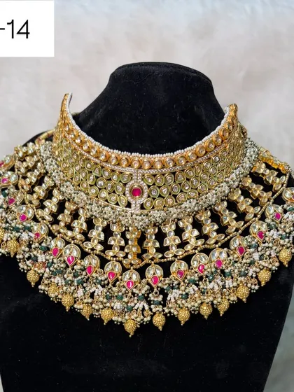 For the bride who wants ultimate grandeur, this is my B-14 heavy bridal rental set. It features intricate kundan and polki work with touches of red and green, designed to make a breathtaking statement.