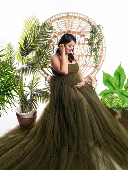 A lovely portrait combining the boho peacock chair with lush greenery. The client's olive green tulle gown fits perfectly with the natural, earthy theme of the setup.