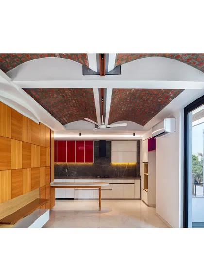 In this open-plan living space, I've used exposed load-bearing brick vaults to create a ceiling that is both structural and beautiful. This ethno-modern approach combines the raw texture of brick with the clean lines of a contemporary kitchen, creating a warm, inviting area for family life that is connected to the outdoors.