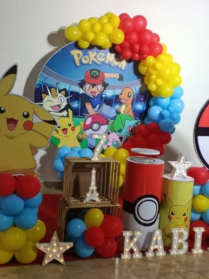 Gotta catch 'em all! A fun Pokemon themed birthday party with a large Pikachu cutout, a Pokeball prop, and a balloon garland in the classic red, yellow, and blue colors.