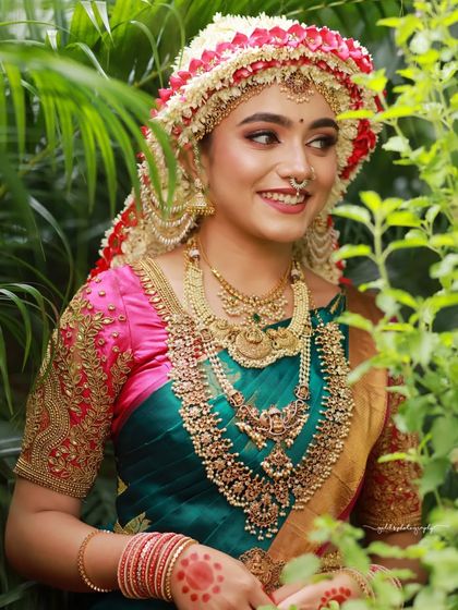 A series of images capturing the joy and beauty of a model in a traditional South Indian bridal look, complete with an elaborate floral headpiece. The focus is on her expressive smile and the rich textures of her attire.