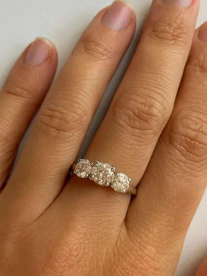 A close-up view of the three-stone diamond ring, showcasing the brilliance and clarity of each hand-selected stone. A true symbol of your journey together.