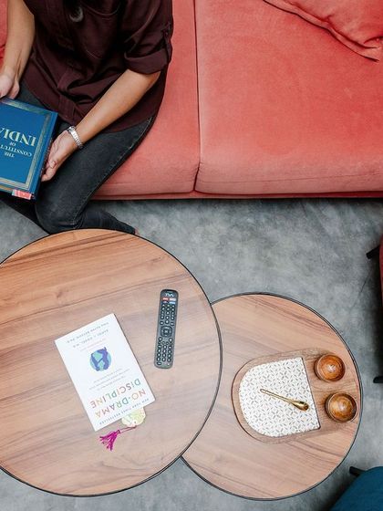 An overhead shot of custom furniture in the T7 T8 apartment, including a blush-colored sofa and nested wooden coffee tables.