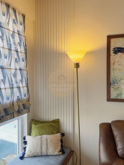 A detail shot of the study nook, showing a fluted wall panel next to a window seat with plush cushions.