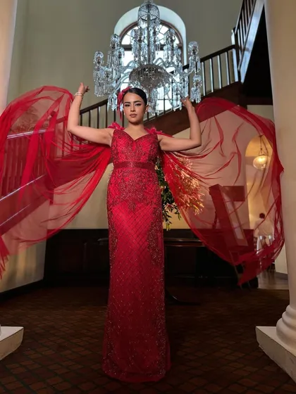 The flowing red cape adds a theatrical touch to this show-stopping look. This is for a bride who is not afraid to be bold.