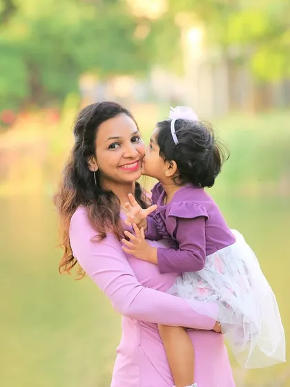 A daughter's sweet kiss for her mom. Outdoor photoshoots are perfect for capturing these spontaneous, love-filled moments in a beautiful, natural setting.
