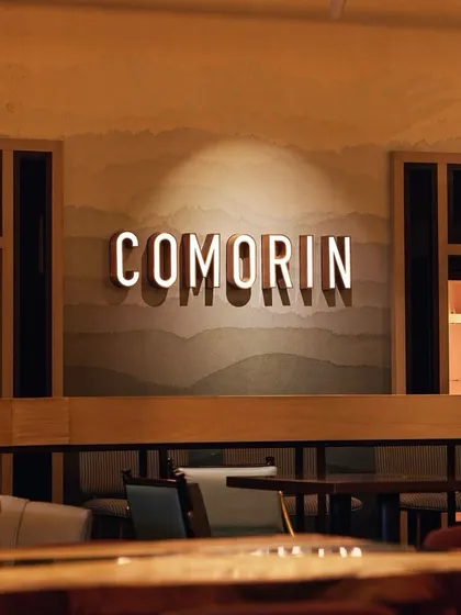 The Comorin name, illuminated against a textured wall, serves as a subtle yet iconic feature in our Gurugram location. It’s a simple statement of the quality and experience we stand for.