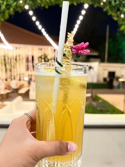 A guest holding a refreshing drink with a custom "More Bubbles" stirrer. It's these small, personalized details that elevate the experience and bring a smile to your guests' faces.