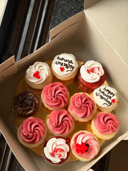 A lovely assortment of cupcakes for a housewarming party. The box includes red velvet, chocolate, and vanilla cupcakes with "happy house warming" messages.
