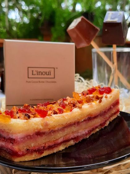 A beautiful slice of our layered fruit pastry, topped with candied fruits. This user-submitted photo also features our hot chocolate dips, showcasing a perfect afternoon treat.