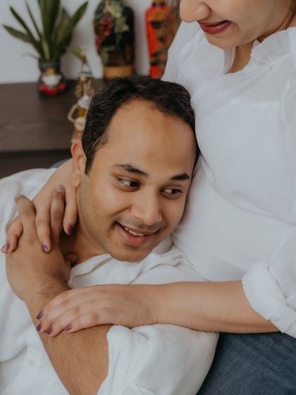 A detailed close-up of the couple's embrace. This shot emphasizes the protective and loving way she holds him, highlighting the deep emotional bond they share as they await their child.