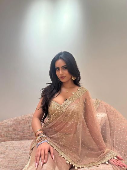 A close-up of the blush pink look, showing the layered bracelets and delicate earrings that complete the outfit.