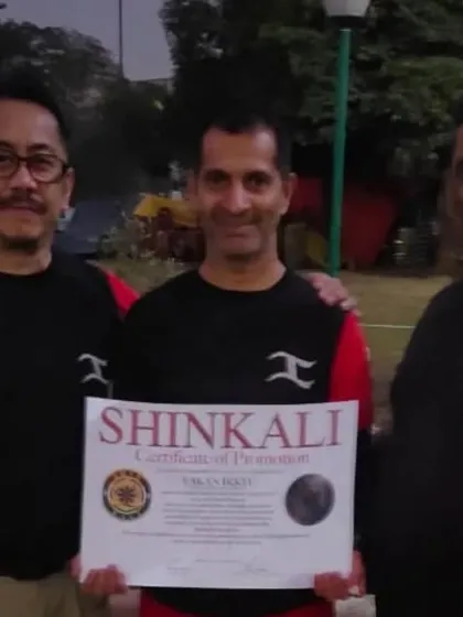 Another student being promoted by Sensei E and myself. It's an honor to guide my students on their martial arts journey and see them grow.