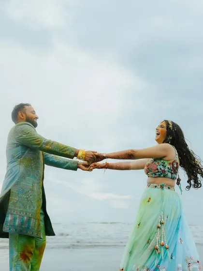 Pure joy and movement as the couple dances on the beach after their Haldi. This candid shot is full of life and captures their carefree spirits.