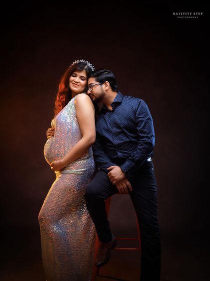 An intimate couple's portrait, with the mother-to-be glowing in a sequined gown. The pose is full of love and anticipation.