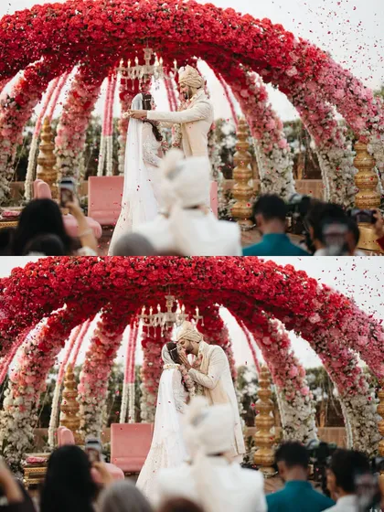 The moment of victory and pure happiness after the varmala exchange. A perfect kiss to seal the deal under a shower of petals.