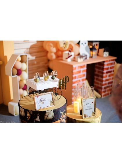 Detailed props for a Harry Potter party, including mini potion bottles, an 'HP' logo, and themed signage.