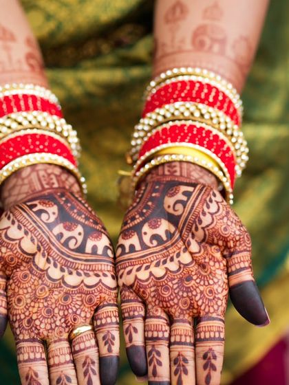 A stunning shot of the henna stain with vibrant red bangles.