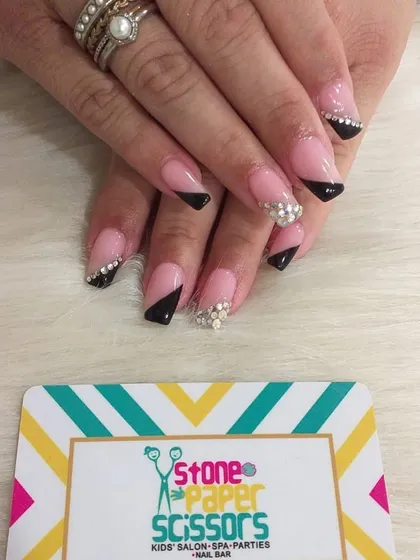 This is a glamorous version of the French tip. I used angled black tips and added clusters of sparkling rhinestones for a dramatic and luxurious finish.