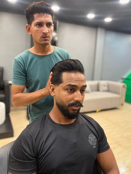 A final check on a classic side-part pompadour. The details matter in achieving this sharp, professional look.