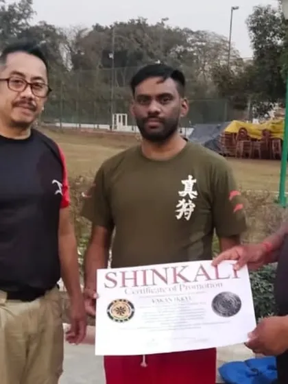 A student receiving his certificate of promotion in SHINKALI. Grading is an important milestone that recognizes a student's progress and dedication.