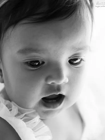 A close-up in black and white captures the sweet, innocent expression of the birthday girl. Her joy is clear even without color.