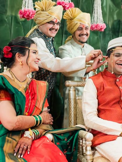 A fun, candid moment during the Kashi Yatra ritual in a Maharashtrian wedding, with family sharing a laugh with the groom.