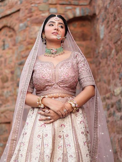 A close-up of the bride in the pastel lehenga, showing the beautiful details of the blouse and the delicate dupatta.