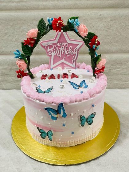 Another shot of the lovely floral arch and butterfly cake.