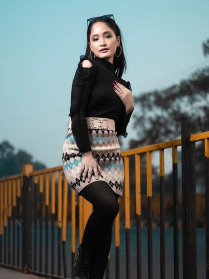 This pose highlights the cold-shoulder detail of the sweater and the overall modern styling of the winter look.