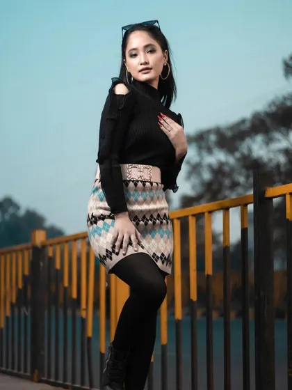 This pose highlights the cold-shoulder detail of the sweater and the overall modern styling of the winter look.