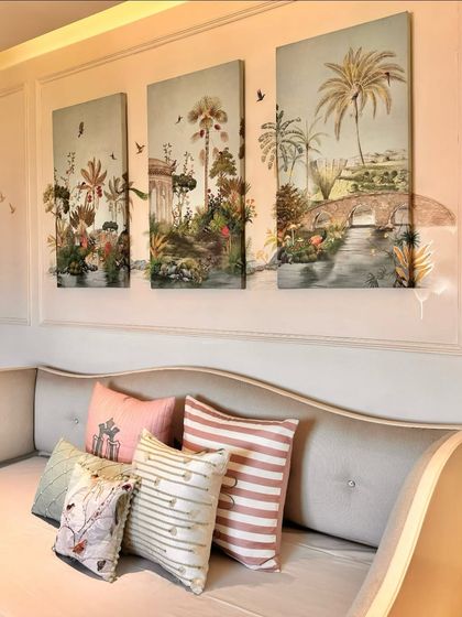 A collection of our cushions styled on a daybed, set against our custom three-panel wall art. The mix of stripes, delicate prints, and a monogrammed cushion in soft pastels creates a charming and personalized space.
