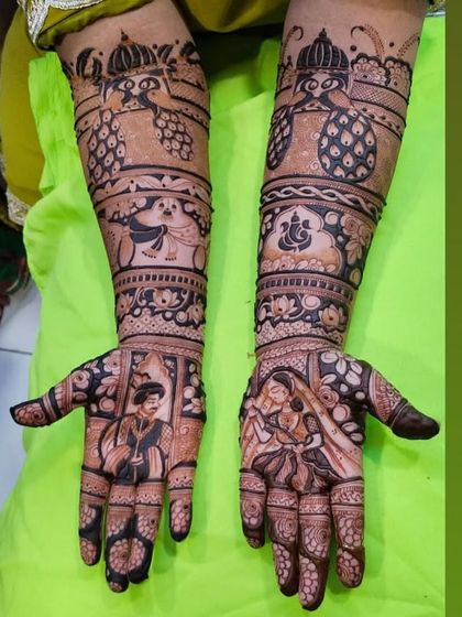 This bridal mehndi features detailed portraits of the couple, along with auspicious symbols like Lord Ganesha, peacocks, and pineapples, which represent warmth and celebration.