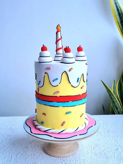 A full view of the comic book style cake on its stand.