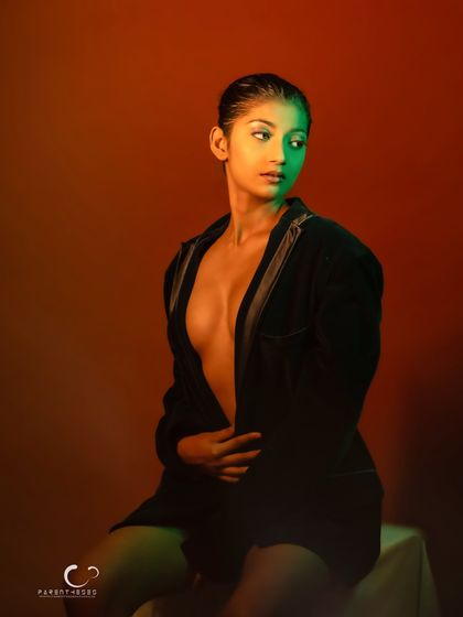 A confident and direct portrait. Her gaze is strong, and the creative lighting adds a unique, artistic flair.