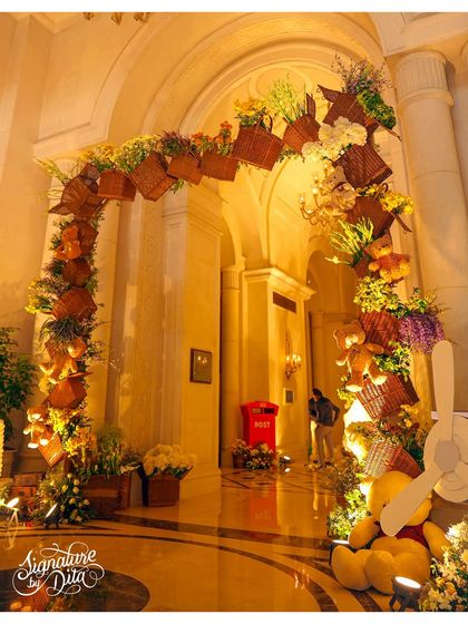 The grand entrance to the 'Teddy in London' party. I designed an archway adorned with flowers, baskets, and teddy bears, with a giant teddy and a vintage airplane prop to complete the travel theme.